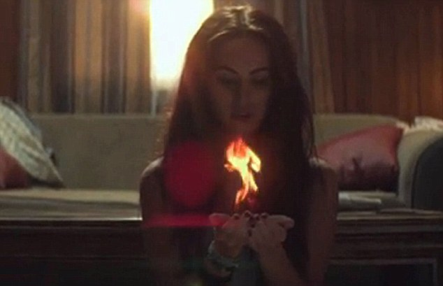 screencap from Love The Way You Lie video showing Megan Fox holding a flame in her cupped hands